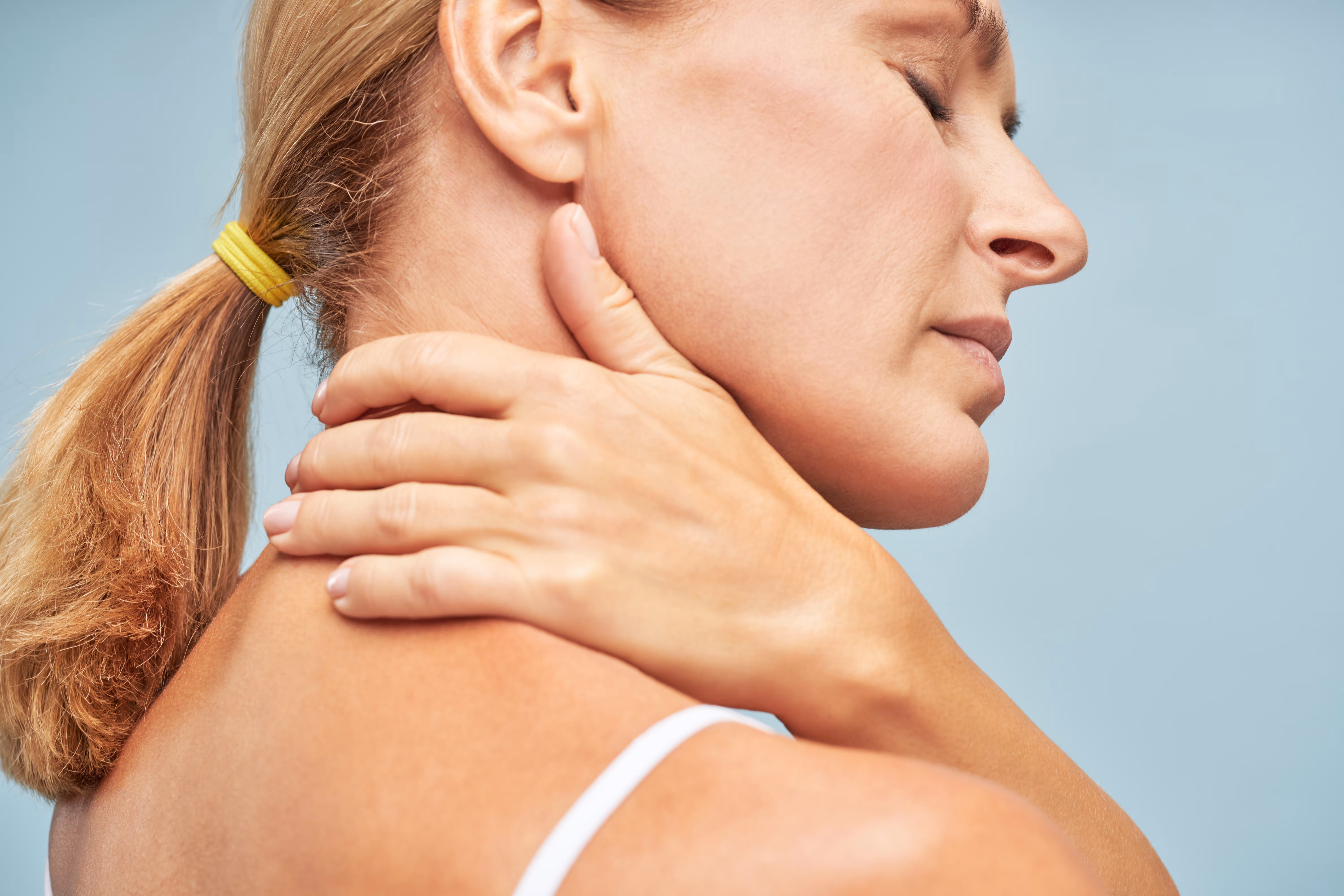 Woman holding the back of her neck in pain